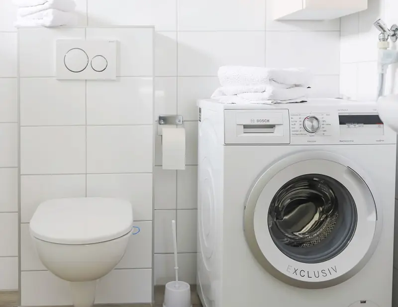 In de badkamer van huisje&nbsp;2 staat de wasmachine, naast het toilet.