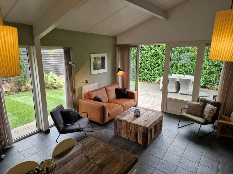 De woonkamer van huisje&nbsp;2, met de openslaande deuren naar het terras en de tuin.
